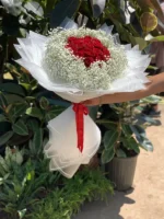 دسته گل رز قرمز با کاغذ سفید